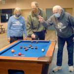 Boys & Girls Clubs of the Olympic Peninsula board member Norma Turner, left, and her husband, long time volunteer Gene Turner, right, play with a bumper pool table with construction facilitator Steve Zenovic in the game room of the new Port Angeles Units building, which has been named the Turner Clubhouse in honor of the Turners contributions to the clubs success. (Keith Thorpe/Peninsula Daily News)