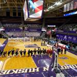 Washington State players kneel on the court as Washington players stand in an otherwise nearly empty Hec Ed Arena during the singing of the national anthem before an NCAA college basketball game Sunday, Jan. 31, 2021, in Seattle. (AP Photo/Elaine Thompson)