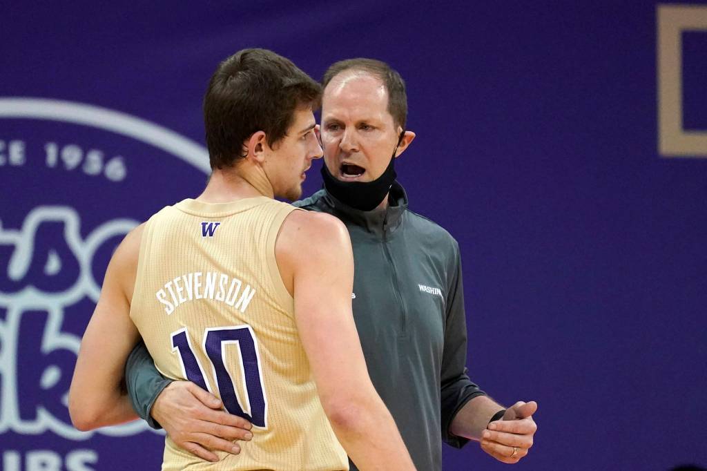 Washington head coach Mike Hopkins, right, has his mask pulled down around his chin as he talks with Erik Stevenson in the first half of an NCAA college basketball game against Washington State, Sunday, Jan. 31, 2021, in Seattle. (AP Photo/Elaine Thompson)