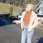 Sidney Murphy stands in the alley behind her home on West 13th Street in Port Angeles. The dirt alley also is the front driveway to several homes build on a sloping hillside and it's the only access for emergency services. (Dave Logan/For Peninsula Daily News)