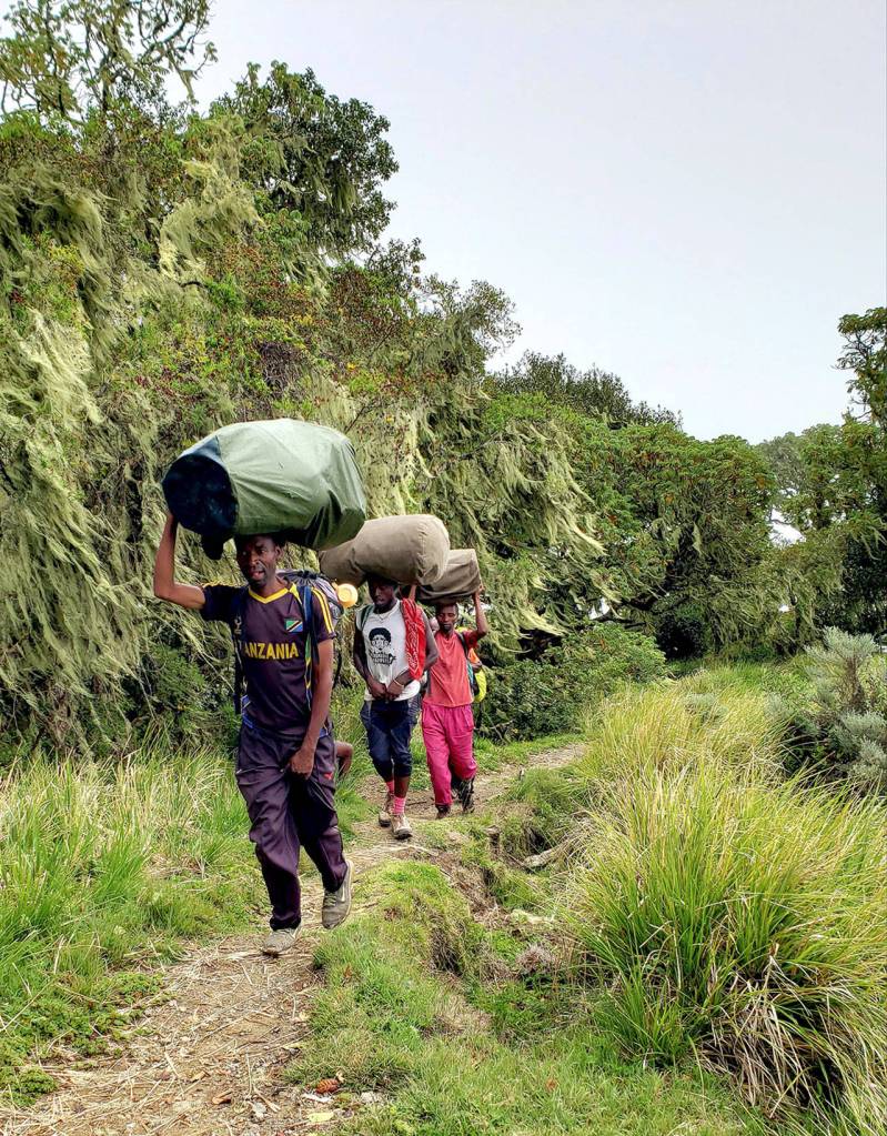 Porters carry climbing gear and supplies up Tanzanias Mount Meru (14,968 feet) during a recent ascension of the peak by Port Angeles Hal Force. (Photo courtesy Hal Force)