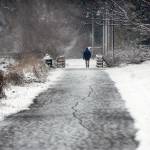 A pedestrian walks along a section of the Waterfront Trail east of downtown Port Angeles as a light snow falls on Thursday afternoon. Many areas of the North Olympic Peninsula were delivered with a taste of winter weather with additional snowfall expected across the region this weekend. (Keith Thorpe/Peninsula Daily News)