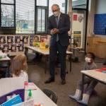 Gov. Jay Inslee speaks with kindergartners in Chelsea Singhs class during a visit to Firgrove Elementary School in Puyallup on Thursday. Students are back in school and all teachers and students are wearing masks. (Ellen M. Banner/The Seattle Times via AP)