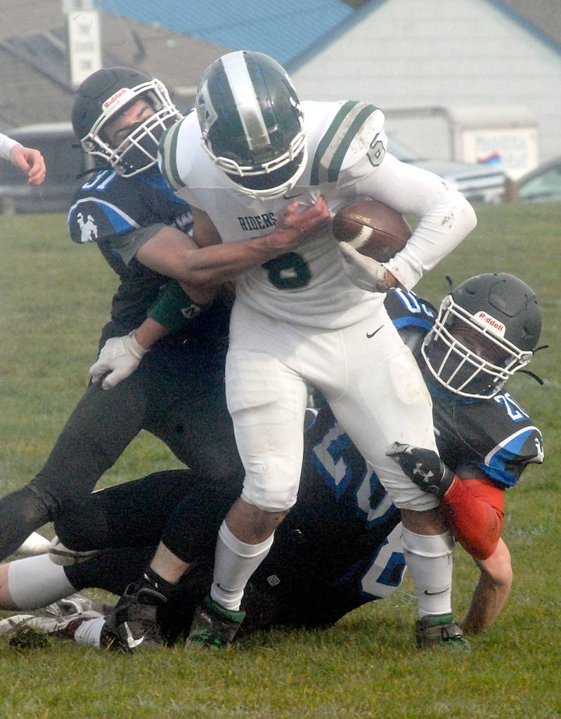 Port Angeles running back Jaziel Livingston is wrapped up by East Jeffersons Nathan Nisbet, left, and Gerald Lindsey in th first quarter on Saturday in Port Angeles. (Keith Thorpe/Peninsula Daily News)