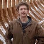 Leo Goolden stands in the wooden hull of Tally Ho, a 1910 cutter he is restoring in the Sequim area. Goolden posted a YouTube video Sunday discussing issues he's had with a neighbor and Clallam County's Department of Community Development. (Sampson Boat Co. via YouTube)