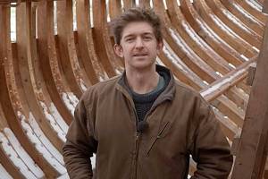 Leo Goolden stands in the wooden hull of Tally Ho, a 1910 cutter he is restoring in the Sequim area. Goolden posted a YouTube video Sunday discussing issues he's had with a neighbor and Clallam County's Department of Community Development. (Sampson Boat Co. via YouTube)