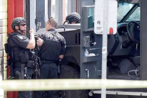 FILE - In this June 6, 2014, file photo, Seattle Police SWAT team officers stand behind an armored vehicle in Seattle's Capitol Hill neighborhood. Lawmakers are on the cusp of overhauling policing and police accountability in Washington state, acting with unusual urgency to curb bad behavior by officers following last year's turbulent protests for racial justice. (AP Photo/Ted S. Warren, File)