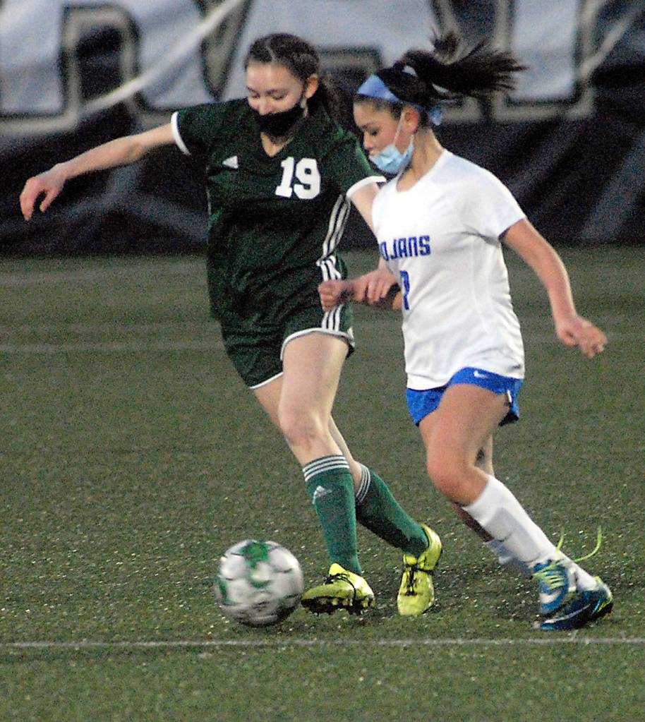 Keith Thorpe/Peninsula Daily News Port Angeles Jada Cargo-Acosta, left, dribbles past Olympics Kaleia Sandback on Thursday night at Peninsula College in Port Angeles.