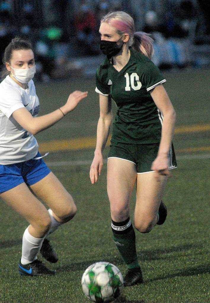 Keith Thorpe/Peninsula Daily News Port Angeles Millie Long, right, looks past the defense of Olympics Claire Caldwell in the first half of Thursday nights match at Peninsula College in Port Angeles.