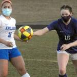Olympics Alexis Valenzuela, left, and Sequims Abigail Schroeder chase after a loose ball during Tuesday nights match at Sequim High School. (Keith Thorpe/Peninsula Daily News)