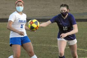 Olympics Alexis Valenzuela, left, and Sequims Abigail Schroeder chase after a loose ball during Tuesday nights match at Sequim High School. (Keith Thorpe/Peninsula Daily News)
