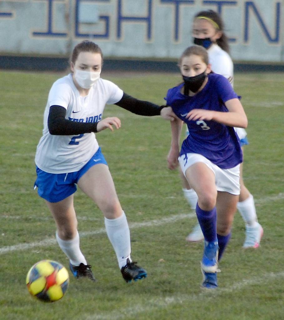 Olympics Claire Caldwell, left, races for the ball with Sequims Taryn Johnson in the first half on Tuesday at Sequim High School. Behind is Johnsons teammate, Alliyah Weber. (Keith Thorpe/Peninsula Daily News)