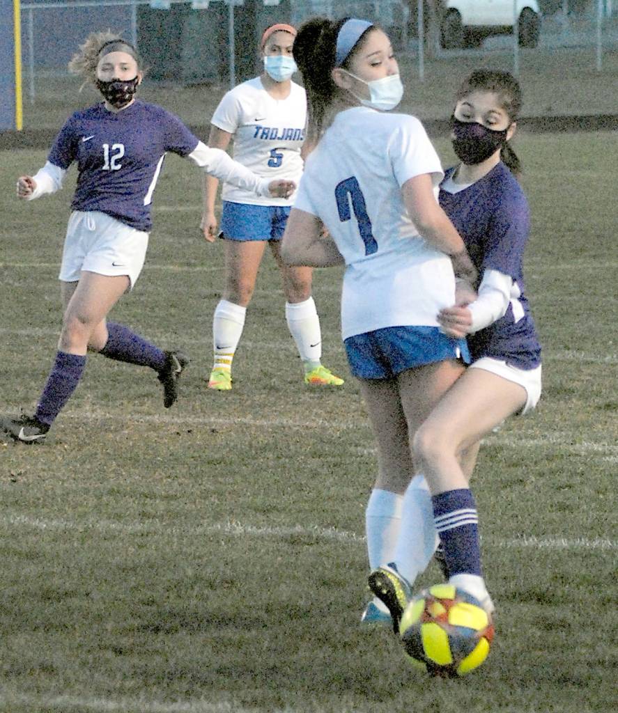 Sequims Alliyah Webber, right, and Olympics Kaleia Sandbeck square off on the ball as Sequims Natalya James, left, and Olympics Alexis Valenzuela look on during Tuesday nights match in Sequim. (Keith Thorpe/Peninsula Daily News)