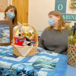 <strong>Keith Thorpe</strong>/Peninsula Daily News
 Feiro Marine Life Center Development Director Linty Hopie, left, and Executive Director Melissa Williams sit with some of the auction items to be sold at the centers Making Waves 2021: Resilience online fundraising event.