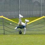 Keith Thorpe/Peninsula Daily News East Jeffersons Cash Holmes crashes over the outfield fence while trying to reach for a home-run ball batted by Port Angeles Johnm Vaara in the third inning on Tuesday at Port Angeles Civic Field.