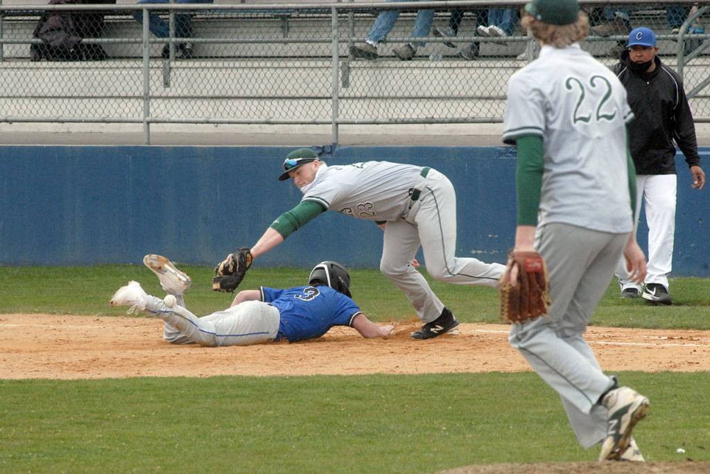 Keith Thorpe/Peninsula Daily News Port Angeles first baseman Adam Watkins reaches for a missed catch from pitcher John Vaara, right, while trying to pick off East Jeffersons Marcus Rich in the fourth inning in Port Angeles on Tuesday.