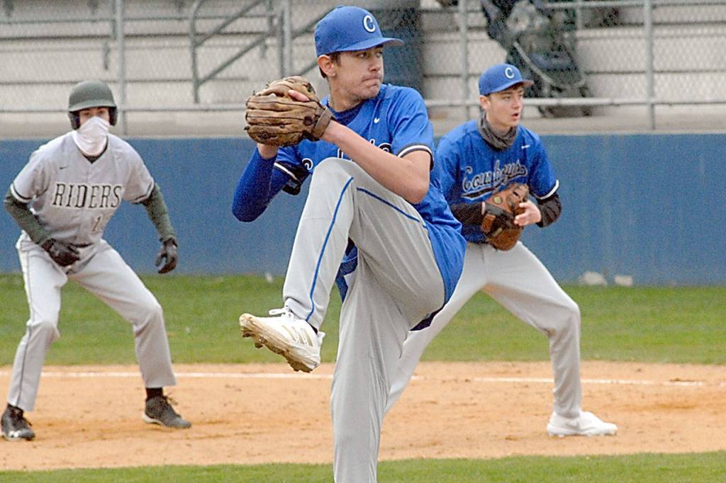 Keith Thorpe/Peninsula Daily News East Jefferson pitcher Hunter Cerna winds up to throw in the third inning as Port Angeles base runner Tanner Price, left, takes his lead off away from East Jefferson first baseman Owen Thorten on Tuesday at Port Angeles Civic Field.