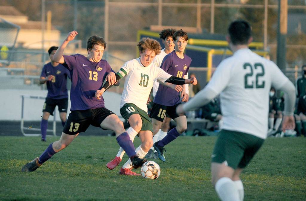 Sequims Brandon Charters, left, and Port Angeles Damon Gunderson vie for possession in a March 25 match in Sequim. The host Wolves shut out their cross-peninsula rivals, 2-0. Looking on are Sequims Eli Gish (13) and Port Angeles Dominick Fischer (22). Michael Dashiell/Olympic Peninsula News Group