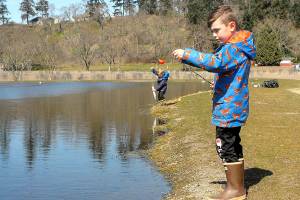 Weston Web, 6, prepares to cast a line at the childrens fishing pond at the Water Reuse Demonstration Site Next to Carrie Blake Park in Sequim on Wednesday as his brother, Bennet, 4, tends to a freshly caught fish. The Sequim boys were taking advantage of a mostly sunny day on the North Olympic Peninsula. (Keith Thorpe/Peninsula Daily News)