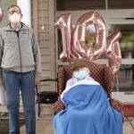 Jim Hansen, left, stands with his mother Lorraine on Friday during a drive by celebration of her 104th birthday on Saturday at the Port Townsend Life Care Center. The local law enforcement, first responders, and friends and family of Lorraine drove through waving and wishing her well. (Zach Jablonski/Peninsula Daily News)