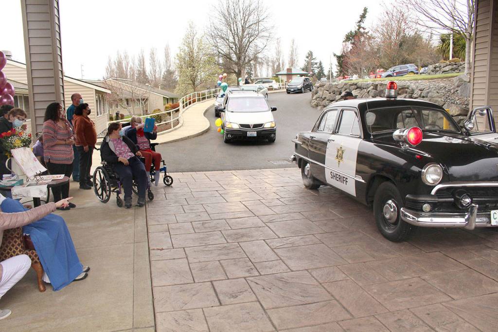 Local law enforcement, first responders, and friends and family of Lorraine Hansen drove through waving and wishing her well Friday morning at the Port Townsend Life Care Center in honor of her 104th birthday on Saturday, April 3, 2021. (Zach Jablonski/Peninsula Daily News)