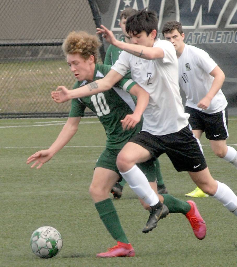 Keith Thorpe/Peninsula Daily News Port Angeles Damon Gundersen, left, gets tangled with Klahowyas Matthew Frank-Cervantes on Saturday at Peninsula College in Port Angeles.