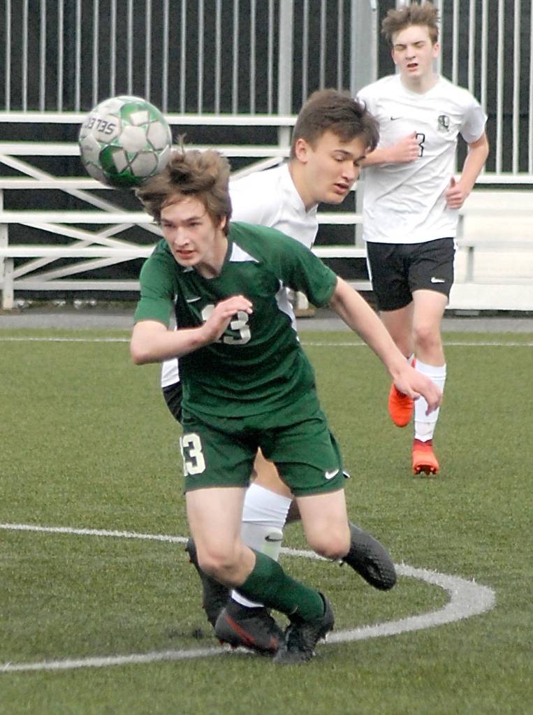 Keith Thorpe/Peninsula Daily News Josiah Long of Port Angeles, front, goes for a header in front of Klayhowas Thomas Dickson and Christopher Beach on Saturday in Port Angeles.