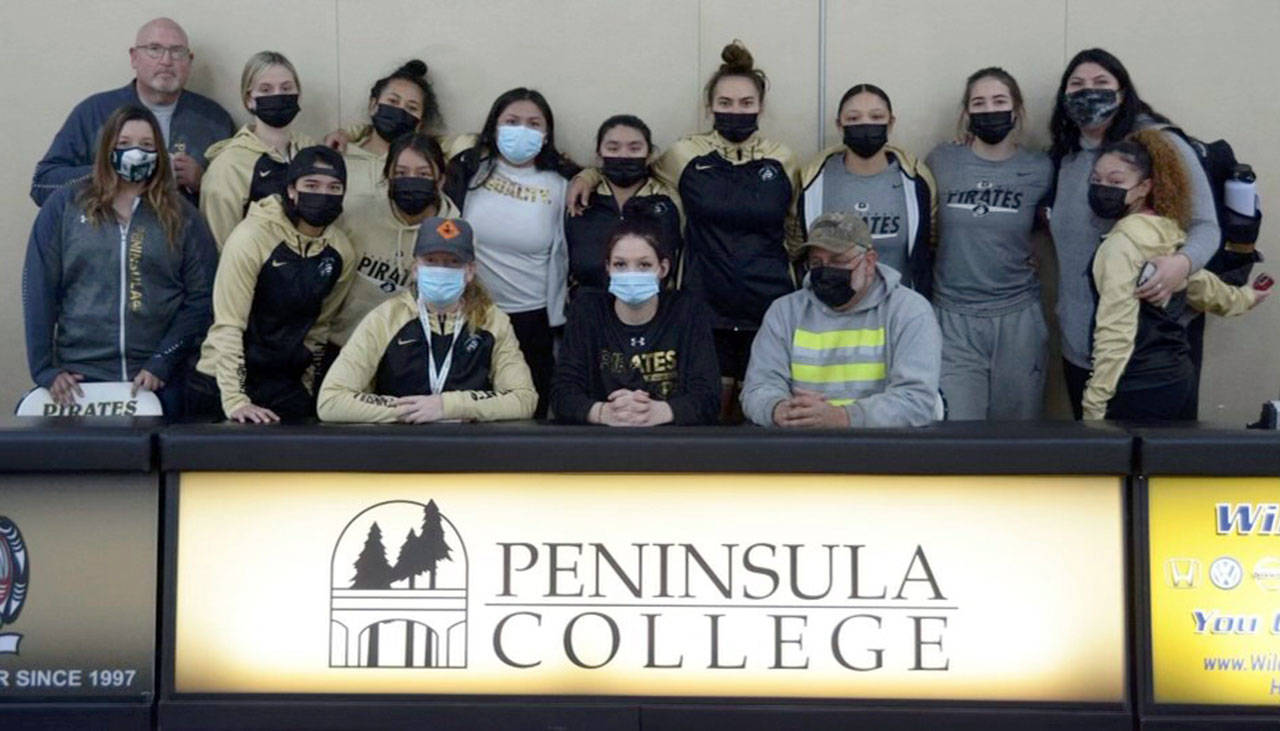 The Peninsula College womens basketball team and coaching staff celebrated the letter of intent signing by Port Angeles senior Madison Cooke, seated center, Friday.