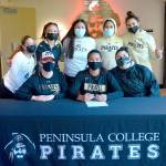 Gina Brown, center, sitting, signs to play with the Peninsula College womens basketball court. At left is Peninsula womens coach Alison Crumb. (Peninsula College)