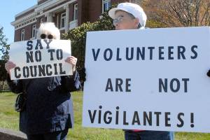 Keith Thorpe/Peninsula Daily News
Darlene Heskett, left, and Patty Pastore hold signs on Saturday in front of the Clallam County Courthouse in Port Angeles protesting what they said is inaction by the Port Angeles City Council in handling homelessness and drug abuse in the city, as well as having been termed "vigilantes" for their cleanup efforts. The pair were part of a group of about 15 people taking part in the protest.