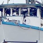 Port Angeles police and the federal Bureau of Alcohol, Tobacco, Firearms and Explosives investigators search the wheelhouse of the Karen L on Sunday. A man was found dead inside the fishing vessel after a fire early Sunday, police said. (Rob Ollikainen/Peninsula Daily News)