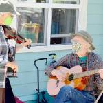 Fiddler Alea Waters, left, and guitarist Lang Russel provide free music outside Port Townsends Recovery Cafe last week. (Diane Urbani de la Paz/Peninsula Daily News)