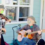 Fiddler Alea Waters, left, and guitarist Lang Russel provide free music outside Port Townsends Recovery Cafe last week. (Diane Urbani de la Paz/Peninsula Daily News)