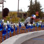 Cameron Colfax, 10, a member of the Jamestown SKlallam tribal youth program, plants pinwheels along the driveway of the tribal Justice Center in Blyn on Tuesday. The pinwheels are part of 3,600 that Dru Froggett, child advocate for the Jamestown SKlallam Tribe, has ensured were placed around the Jamestown campus, at the Jamestown Medical Clinic in Sequim and at Lower Elwha Klallam facilities in Port Angeles as part of a national effort to raise awareness of child abuse prevention. (Keith Thorpe/Peninsula Daily News)