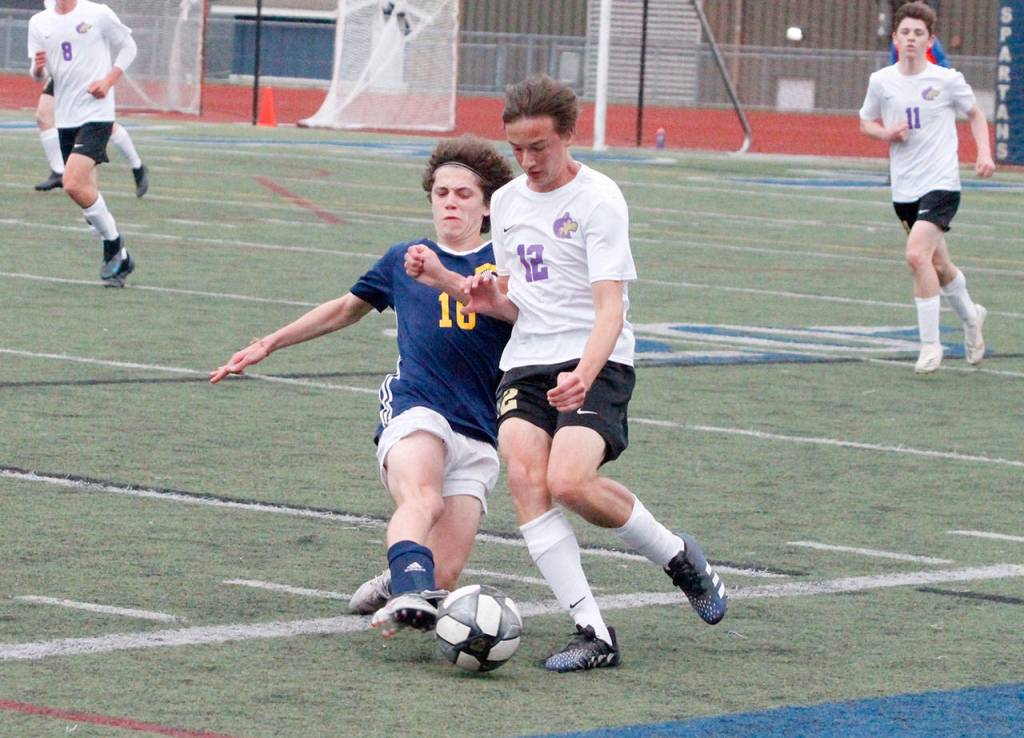 Sequims Ethan Anderson evades a tackle from Bainbridges Wyatt Friedman during the Olympic League Boys Soccer Championship. (Mark Krulish/Kitsap News Group)