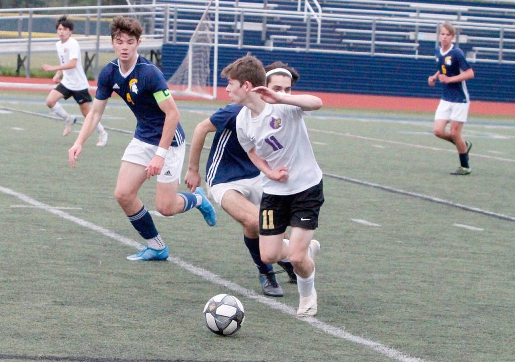 Sequims Ethan Knight squeaks by the Bainbridge defense during the Olympic League Boys Soccer Championship. (Mark Krulish/Kitsap News Group)