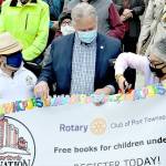 Port Townsend Mayor Michelle Sandoval cuts an alphabet ribbon to kick off the Dolly Parton Imagination Library registration project in Jefferson County on Monday. The Rotary Club of Port Townsend, which organized the campaign, was represented by District Governor Greg Horn, center, and club president Lee Hoffman. (Diane Urbani de la Paz/Peninsula Daily News)