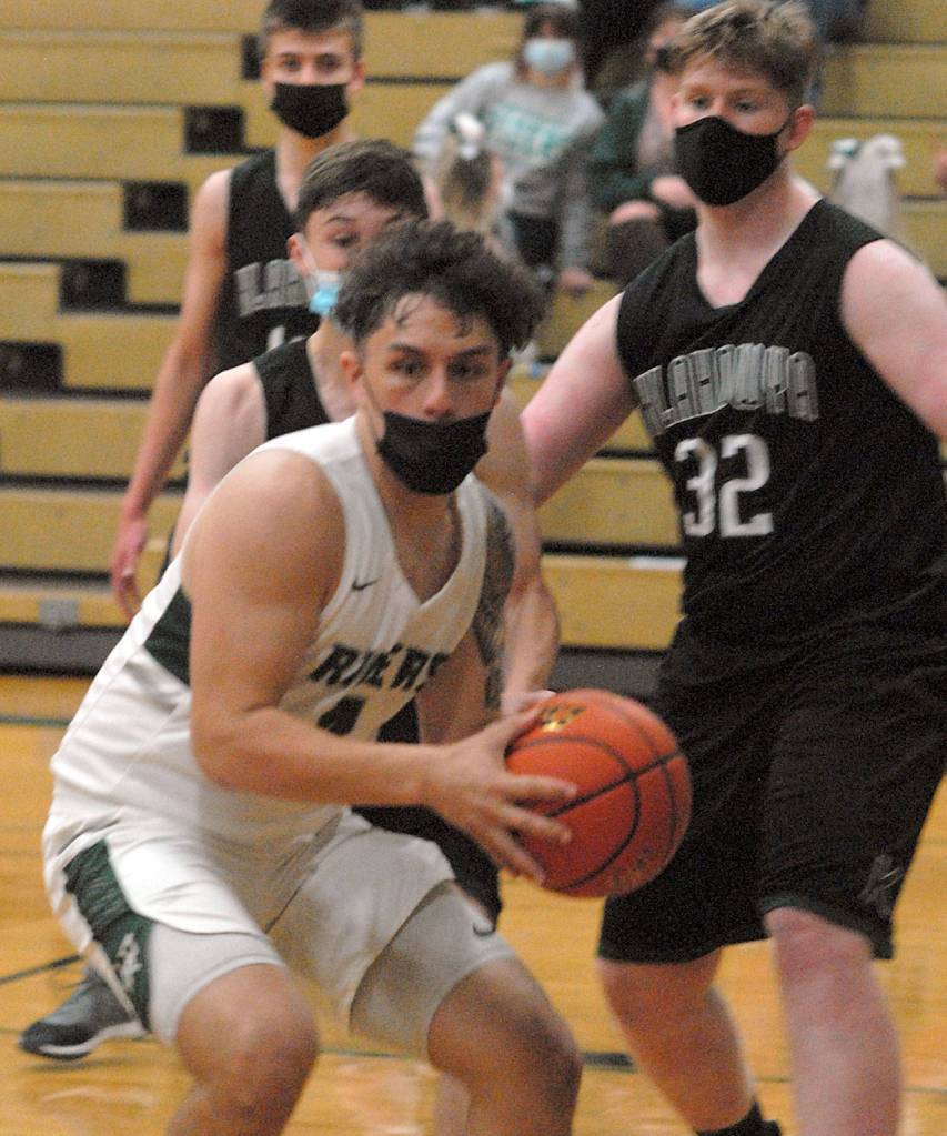 Keith Thorpe/Peninsula Daily News Port Angeles Jeremiah Hall, front, looks for the lane as Klahowyas Cannon Leifeste, right, defends on Thursday in Port Angeles.