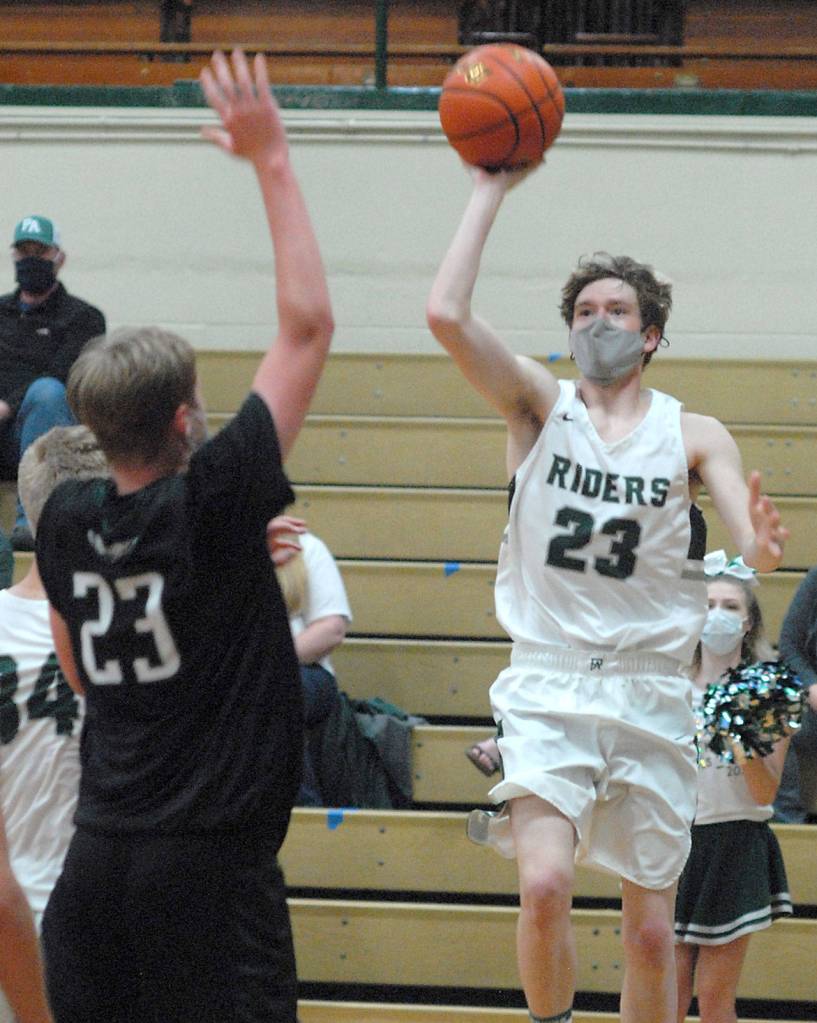 Keith Thorpe/Peninsula Daily News Port Angeles Michael Soule, right, make a one-handed shot for the basket as Klahowyas Robbie Slater defends the lane on Thursday in Port Angeles.