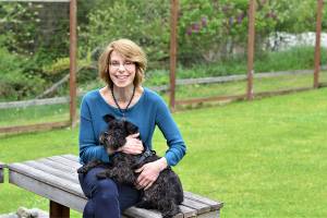 Port Townsend novelist JoAnne Tompkins, at home with her schnauzer Oscar, has released her debut, What Comes After, to glowing reviews across the nation. (Diane Urbani de la Paz/Peninsula Daily News)