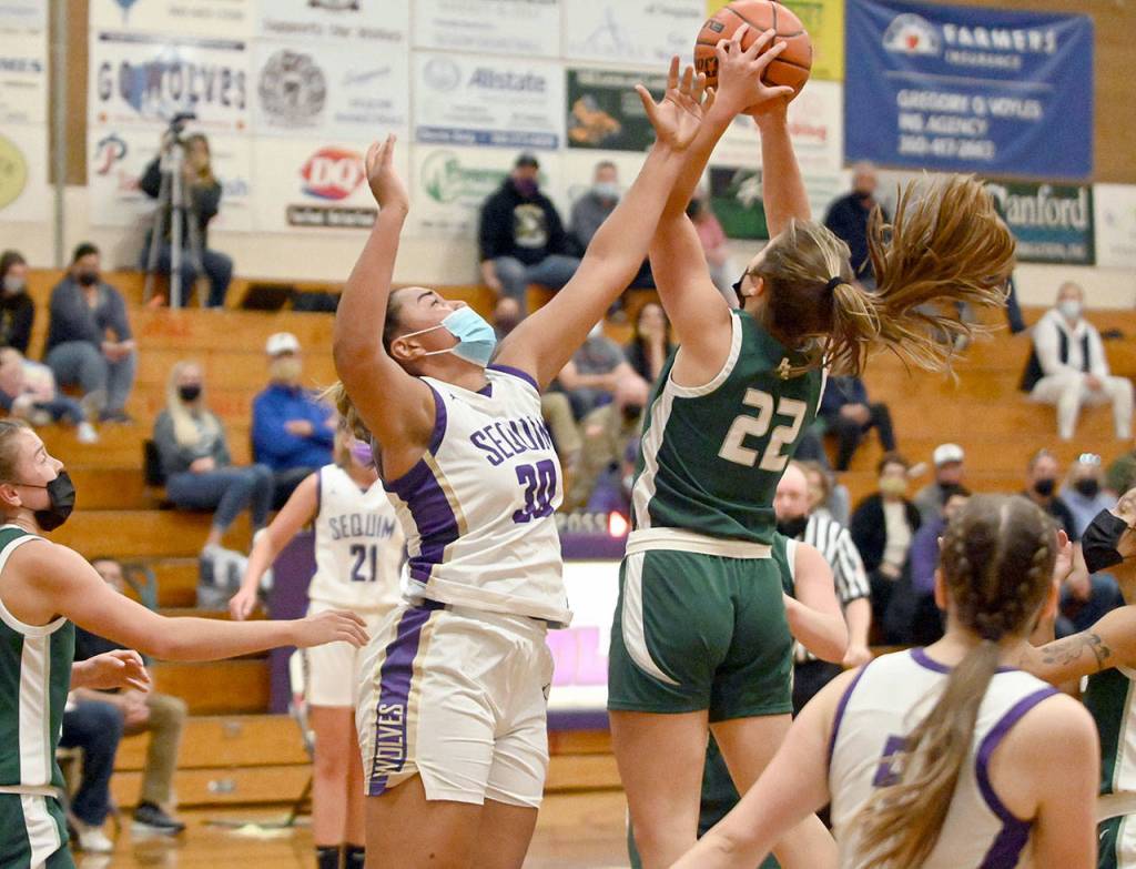 Port Angeles Eve Burke, right, elevates for a shot while blanketed by Sequims Jayla Julmist during the Roughriders 67-58 win over the Wolves on Wednesday. (Michael Dashiell/Olympic Peninsula News Group)