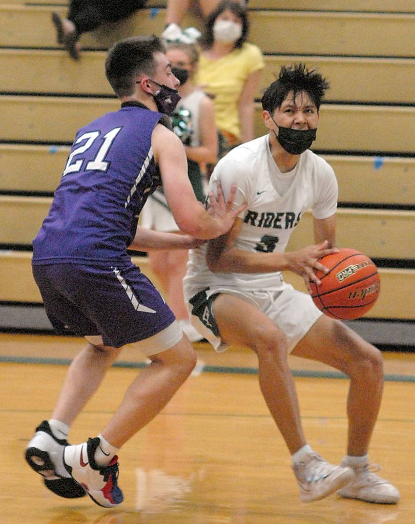 Port Angeles Quanah Wheeler, right, fends off the defense of Seqyims Jayden Possin on Wednesday night in Port Angeles. (Keith Thorpe/Peninsula Daily News)
