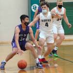 Sequims Isiah Moore, left, is defended by Port Angeles Jeremiah Hall, center, and Adam Watkins in the first quarter of play on Wednesday at Port Angeles High School. (Keith Thorpe/Peninsula Daily News)