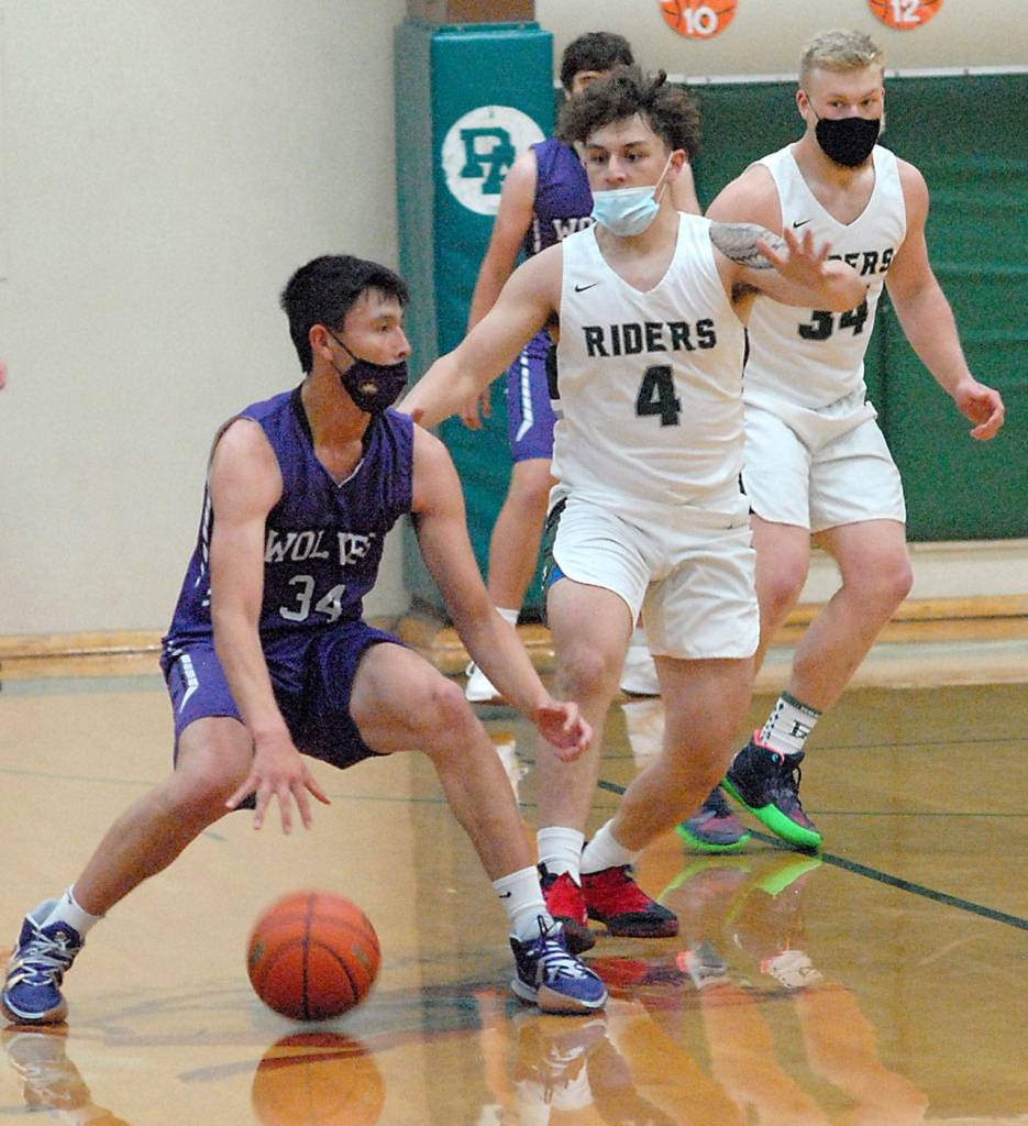 Sequims Isiah Moore, left, is defended by Port Angeles Jeremiah Hall, center, and Adam Watkins in the first quarter of play on Wednesday at Port Angeles High School. (Keith Thorpe/Peninsula Daily News)