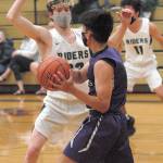 Port Angeles Michael Soule, left, blocks the progress of Sequims Krislian Mingoy as Soules teammate, Xander Maestas, looks on from across court on Wednesday night in Port Angeles. (Keith Thorpe/Peninsula Daily News)