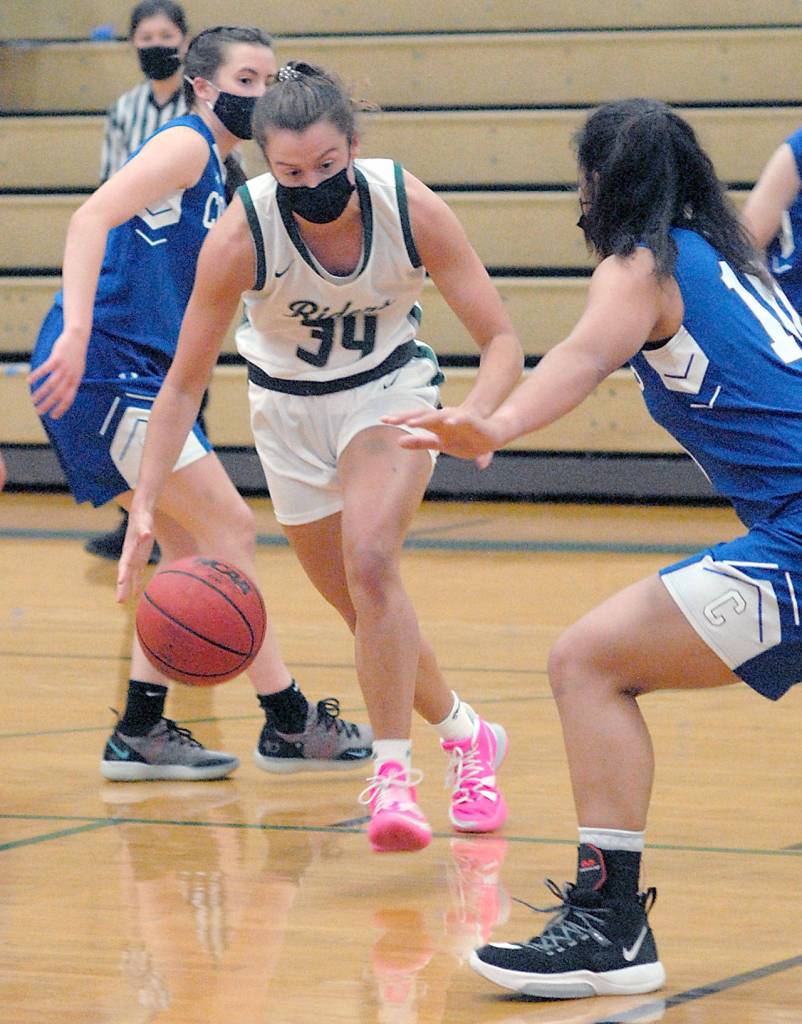 Port Angeles Jaida Wood, center, drives to the lane past East Jeffersons Soso Johnston, left, and Gina Brown, right, during Tuesdays game at Port Angeles High School. (Keith Thorpe/Peninsula Daily News)