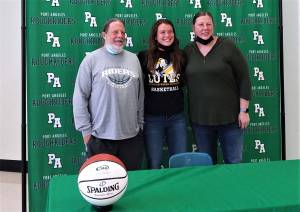 From left, Port Angeles girls basketball coach Michael Poindexter, Jaida Wood and assistant coach Jennifer Rogers at Wood's signing ceremony to play college basketball at Pacific Lutheran University. (Pierre LaBossiere/Peninsula Daily News)