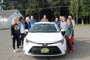 Past winners of the Great Olympic Peninsula Duck Derby grand prize gather at Swain's General Store with Wilder Toyota owner Dan Wilder to gaze upon this year's top prize, a 2021 Toyota Corolla, which is donated by Wilder. From left are Angeline Parrish, 2019 winner;  Kim Skerbeck, 1995; Mary and Harry Hebert, 2002; Tom Baerman, winner along with wife Jackie in 2011; Dan Wilder; Steve Zenovic (2018); Annette Wendell, 1992; Dan Sinnes, 1998 and Zenovic's wife Nina. All of the past 30 winners of the car have been from Port Angeles and Sequim, except for one.