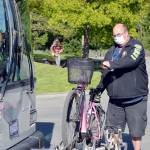 Jefferson Transit driver Lloyd Eisenman loads an electric bicycle onto the rack of the Sequim-bound bus Friday at the Haines Place transit center in Port Townsend. Heavy e-bikes must ride in the rack position closest to the bus bumper to avoid stressing the rack. (Diane Urbani de la Paz/Peninsula Daily News)