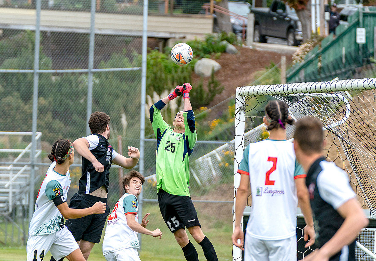 Northern Peninsula Football Club goalkeeper, Hayden Price (25), makes the save during a Western Washington Premier League 2 match Sunday against the Gala FC from Mill Creek played in Port Townsends Memorial Field. Teammates Silas DeWyse, 14, Raul Medina, 21 and Trillium DeWyse, 2, look on. (Steve Mullensky/for Peninsula Daily News)